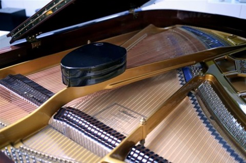 OVAL Sound System posé sur la table d’harmonie d’un piano Fazioli